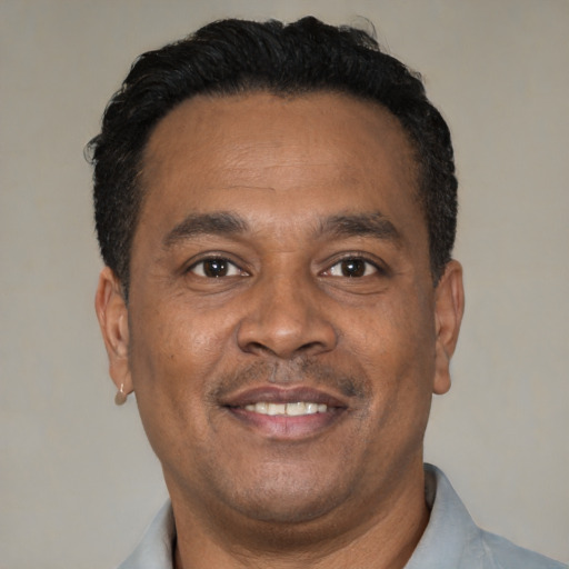 Joyful latino adult male with short  black hair and brown eyes