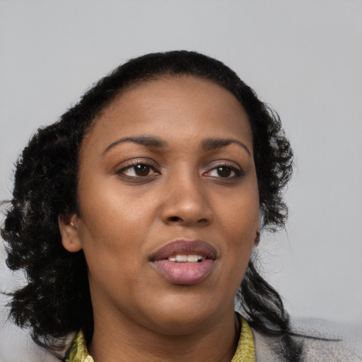 Joyful black young-adult female with long  black hair and brown eyes