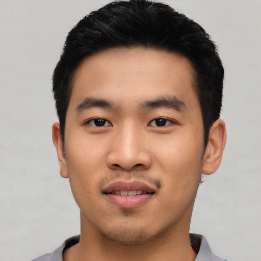 Joyful asian young-adult male with short  black hair and brown eyes