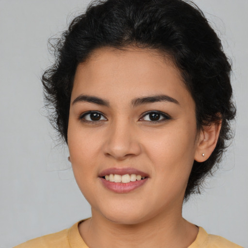Joyful latino young-adult female with long  brown hair and brown eyes
