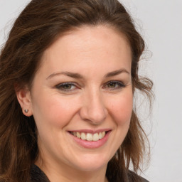 Joyful white adult female with long  brown hair and brown eyes