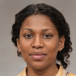 Joyful black adult female with medium  brown hair and brown eyes