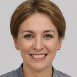 Joyful white adult female with medium  brown hair and grey eyes