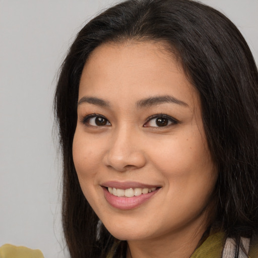 Joyful asian young-adult female with long  brown hair and brown eyes