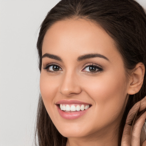 Joyful white young-adult female with long  brown hair and brown eyes