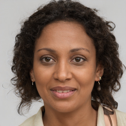 Joyful black adult female with medium  brown hair and brown eyes