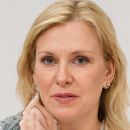 Joyful white adult female with medium  brown hair and blue eyes