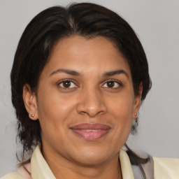 Joyful latino adult female with medium  brown hair and brown eyes