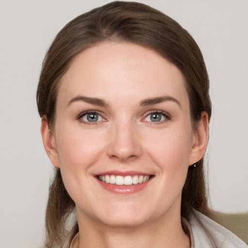 Joyful white young-adult female with medium  brown hair and grey eyes