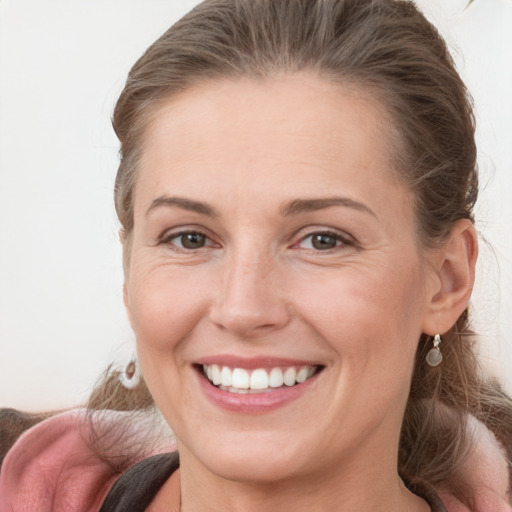 Joyful white young-adult female with medium  brown hair and grey eyes