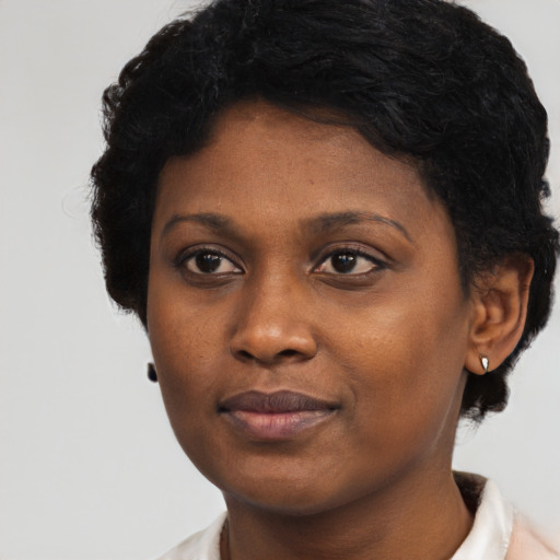 Joyful black young-adult female with short  black hair and brown eyes