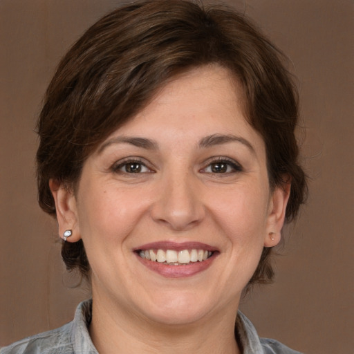 Joyful white adult female with medium  brown hair and brown eyes