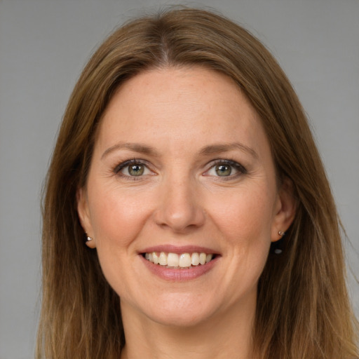 Joyful white adult female with long  brown hair and green eyes