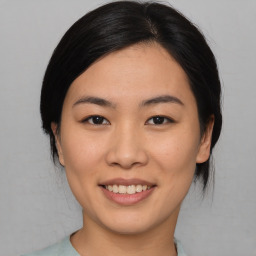 Joyful asian young-adult female with medium  black hair and brown eyes