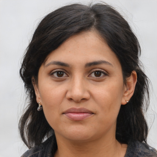 Joyful latino adult female with medium  brown hair and brown eyes