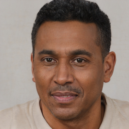 Joyful black adult male with short  black hair and brown eyes