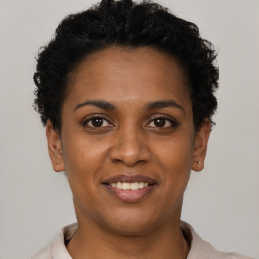 Joyful black young-adult female with short  brown hair and brown eyes
