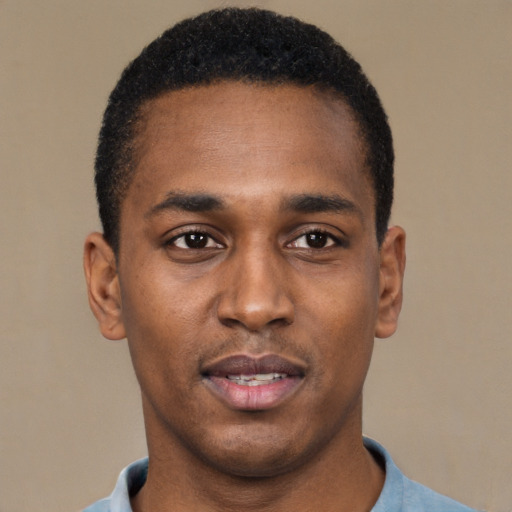 Joyful black young-adult male with short  black hair and brown eyes