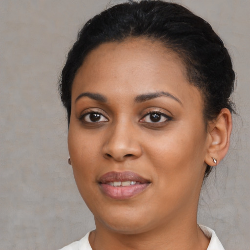 Joyful black young-adult female with short  black hair and brown eyes