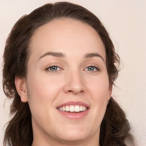 Joyful white young-adult female with long  brown hair and grey eyes