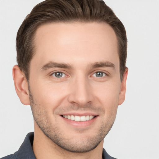 Joyful white young-adult male with short  brown hair and grey eyes