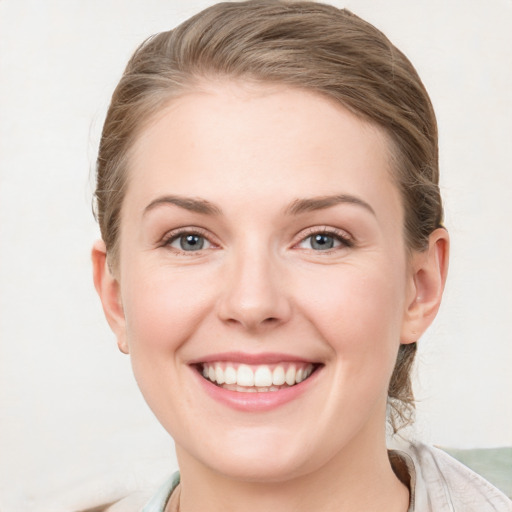 Joyful white young-adult female with medium  brown hair and blue eyes