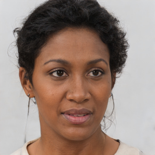 Joyful black young-adult female with short  brown hair and brown eyes