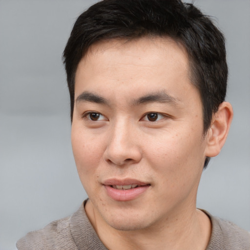 Joyful asian young-adult male with short  brown hair and brown eyes