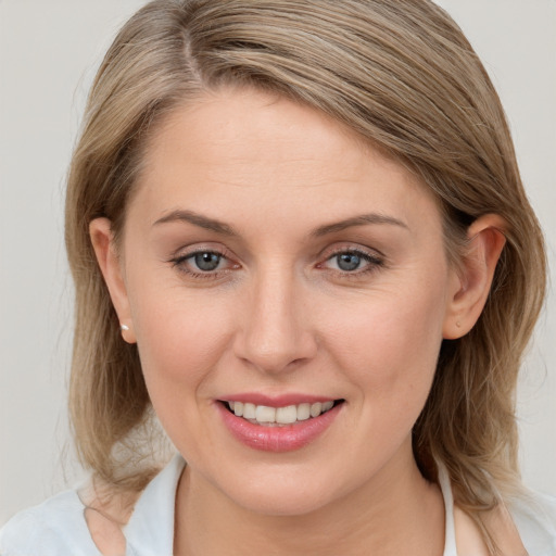 Joyful white young-adult female with medium  brown hair and blue eyes