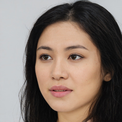 Joyful asian young-adult female with long  black hair and brown eyes