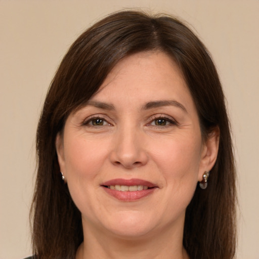 Joyful white adult female with long  brown hair and brown eyes