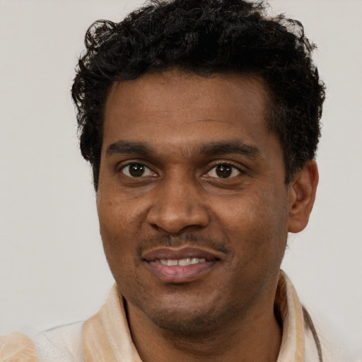 Joyful black young-adult male with short  brown hair and brown eyes