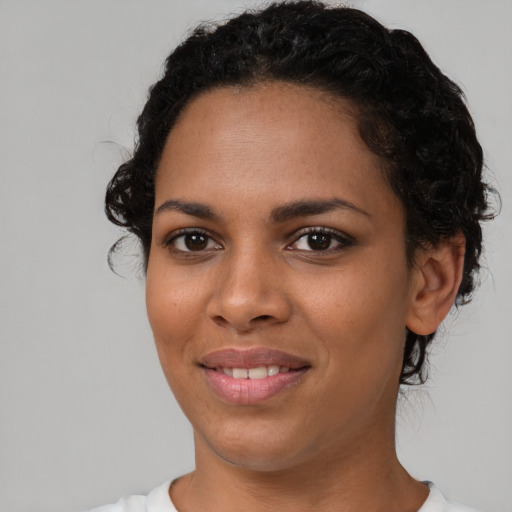 Joyful black young-adult female with short  brown hair and brown eyes
