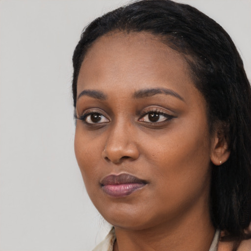 Joyful black young-adult female with long  black hair and brown eyes