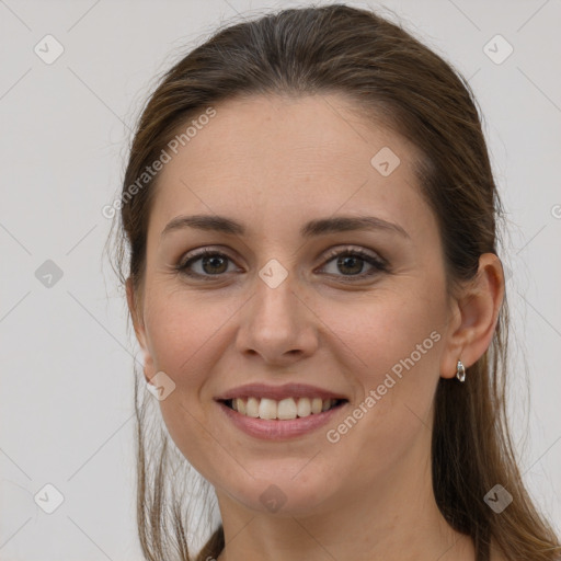 Joyful white young-adult female with long  brown hair and brown eyes