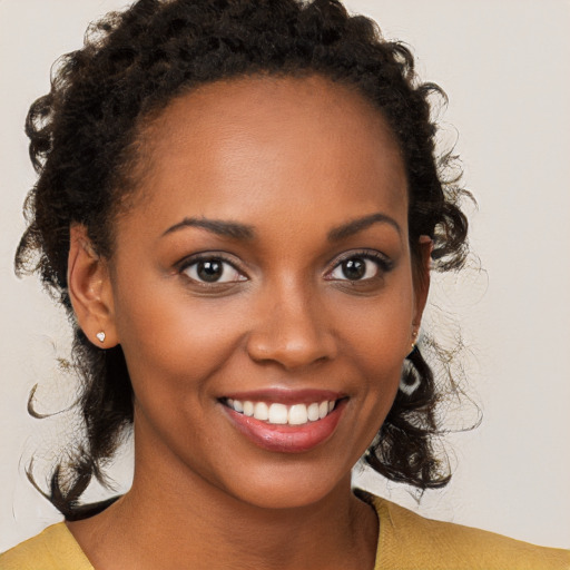 Joyful black young-adult female with medium  brown hair and brown eyes