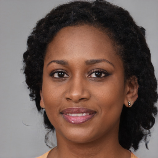 Joyful black young-adult female with medium  black hair and brown eyes