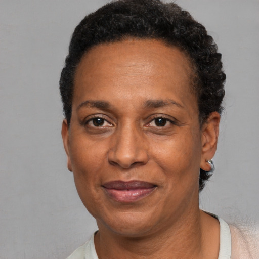 Joyful black adult female with short  black hair and brown eyes