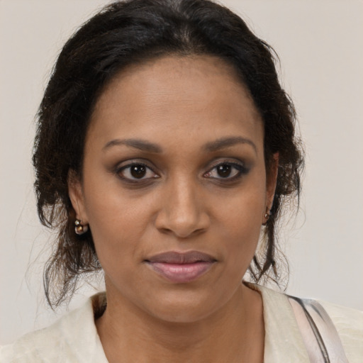 Joyful black young-adult female with medium  brown hair and brown eyes
