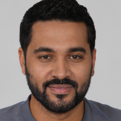 Joyful latino young-adult male with short  black hair and brown eyes