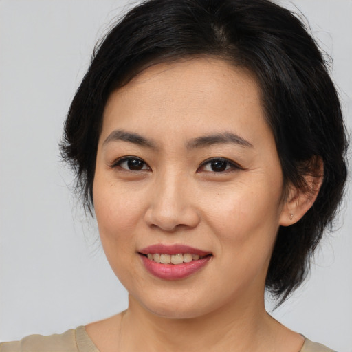 Joyful asian young-adult female with medium  brown hair and brown eyes