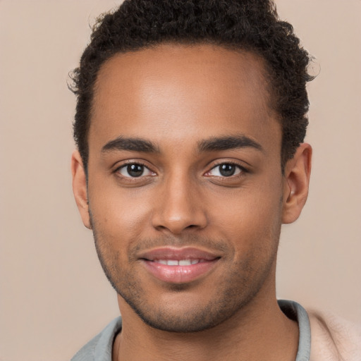 Joyful black young-adult male with short  brown hair and brown eyes