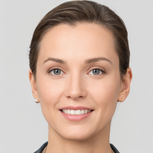 Joyful white young-adult female with short  brown hair and grey eyes