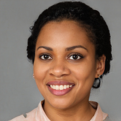 Joyful black young-adult female with short  black hair and brown eyes