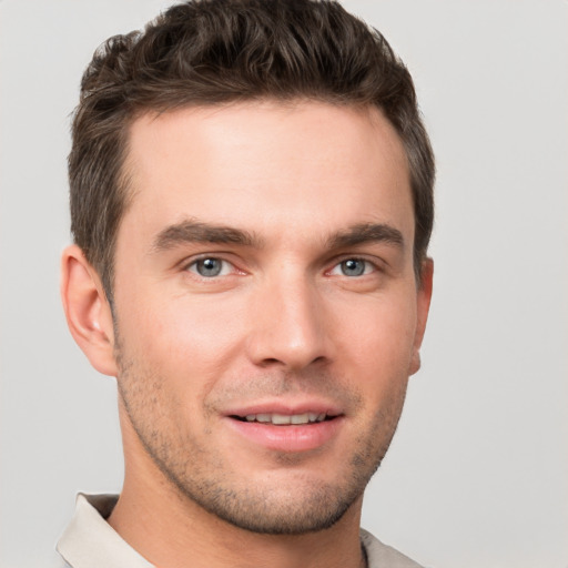 Joyful white young-adult male with short  brown hair and grey eyes