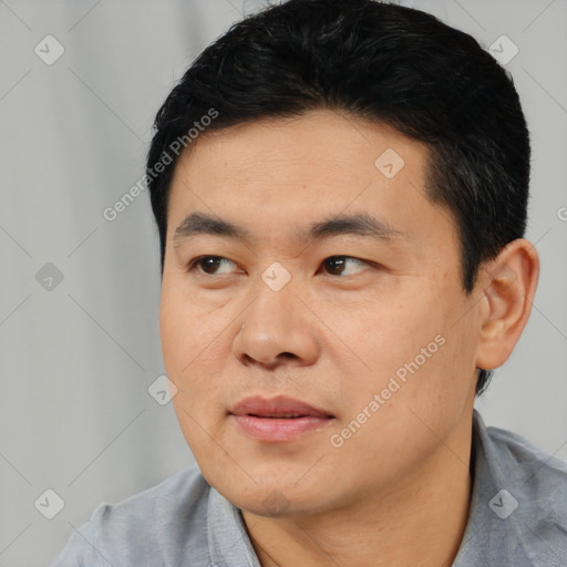 Joyful asian young-adult male with short  black hair and brown eyes