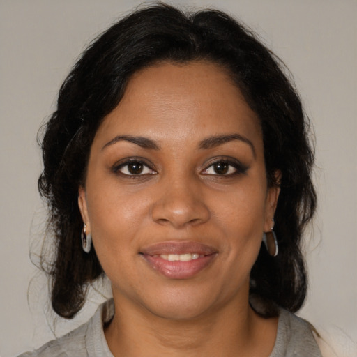 Joyful black adult female with medium  brown hair and brown eyes