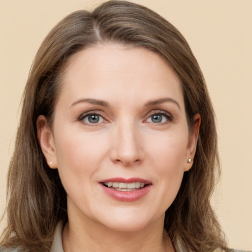 Joyful white young-adult female with long  brown hair and grey eyes