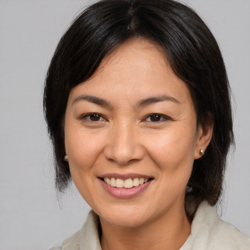 Joyful asian adult female with medium  brown hair and brown eyes