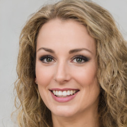 Joyful white young-adult female with long  brown hair and green eyes